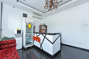 a living room with a refrigerator and a red couch at Hotel O Gemilang in Kuala Terengganu