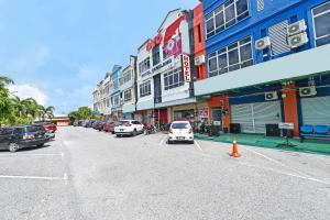 a street with cars parked in front of buildings at Hotel O Gemilang in Kuala Terengganu