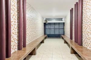 a hallway with wooden benches in a building at Hotel O Kbr Home in Tangerang