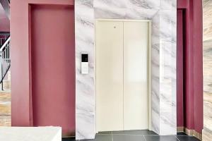 a white elevator in a room with pink walls at Hotel O Kbr Home in Tangerang