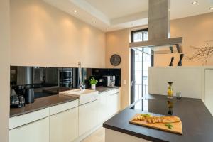 a kitchen with white cabinets and a cutting board on a counter at Villa Philine - Apt. 27 Arwen in Ostseebad Sellin +19 photos