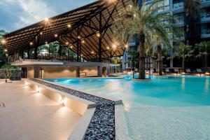 ein Schwimmbad vor einem Gebäude in der Unterkunft tropics Kamala Apartment CTG L609, Several Pools, Gym & Rooftop in Kamala Beach