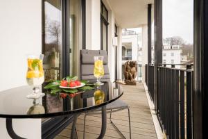 a balcony with a glass table with fruit and wine glasses at Villa Philine - Meerblick-Appartement 27 "Arwen" in Ostseebad Sellin