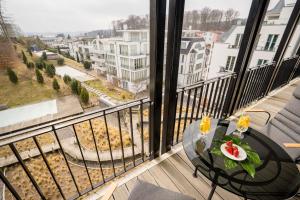 a balcony with a table and a view of a city at Villa Philine - Meerblick-Appartement 27 "Arwen" in Ostseebad Sellin +21 photos