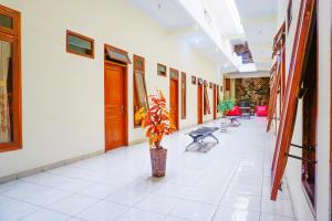 a hallway with a vase with a plant in it at Flagship 90723 Berlima Guest House Syariah in Malang