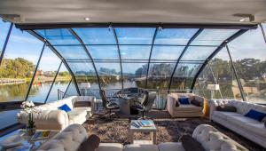 a large room with couches and chairs in a boat at BOATEL Riverdream Luxury Houseboat in Gol Gol