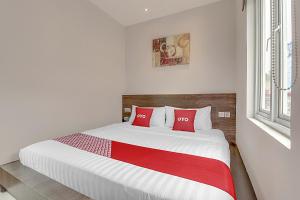 A bed or beds in a room at Collection O Cihampelas Near Ciwalk Formerly Regia Cihampelas