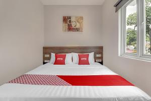 A bed or beds in a room at Collection O Cihampelas Near Ciwalk Formerly Regia Cihampelas