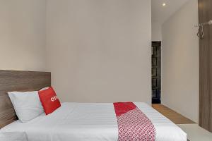 A bed or beds in a room at Collection O Cihampelas Near Ciwalk Formerly Regia Cihampelas