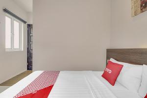 A bed or beds in a room at Collection O Cihampelas Near Ciwalk Formerly Regia Cihampelas