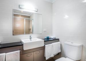 a bathroom with a toilet, sink, and bathtub at Novotel Darwin Airport in Darwin