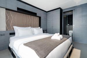 a bedroom with a large white bed with towels on it at Tropics Kamala 2BR Apartment CTG L702-3, Four Pools, Close beach & Phuket Fantasea in Kamala Beach +25 photos