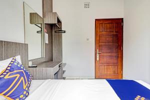 a bedroom with a bed and a wooden door at Hotel O Cihampelas Near Ciwalk Formerly D'River Guest House in Bandung