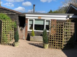a house with two potted plants in front of it at Meerkat Manor in Coddington