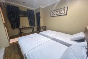 Postel nebo postele na pokoji v ubytování OYO 90411 Perdana Hotel Labuan