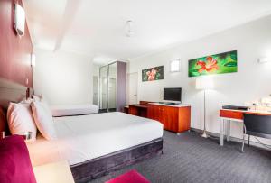 a hotel room with a bed and a desk at Novotel Darwin Airport in Darwin
