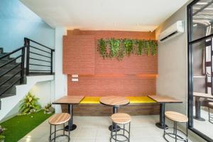 a room with a brick wall and two tables and stools at Collection O Millenium Inn 2 in Medan