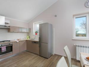 a kitchen with a stainless steel refrigerator and a window at Detached villa with private pool located on hill overlooking Kvarner in Hrvatini