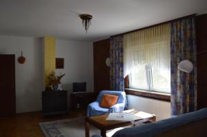 a living room with a blue chair and a window at Bibinje Apartment in Bibinje