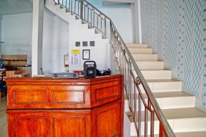 Eine hölzerne Kommode mit einer Kamera darauf neben einer Treppe in der Unterkunft Hotel O Gurusinga Guesthouse in Medan