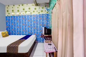 a bedroom with a bed and a blue wall at OYO Life 91060 Villa Wijaya Homestay in Pasuruan