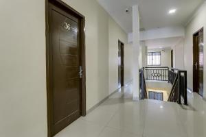 einen Flur mit einer schwarzen Tür und einer Treppe in der Unterkunft OYO 90981 X2 Homestay in Nagoya
