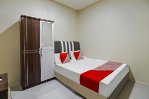 ein Schlafzimmer mit einem Bett mit roten Kissen in der Unterkunft OYO 90981 X2 Homestay in Nagoya