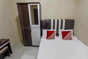 ein Schlafzimmer mit einem Bett mit roten und weißen Kissen in der Unterkunft OYO 90981 X2 Homestay in Nagoya + 17 Fotos