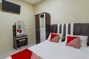 ein Schlafzimmer mit einem Bett mit roten und weißen Kissen in der Unterkunft OYO 90981 X2 Homestay in Nagoya