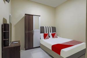 ein Schlafzimmer mit einem Bett mit roten Kissen in der Unterkunft OYO 90981 X2 Homestay in Nagoya