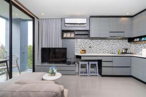 eine Küche und ein Wohnzimmer mit Sofa und Tisch in der Unterkunft tropics Kamala Apartment CTG L609, Several Pools, Gym & Rooftop in Kamala Beach