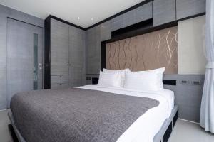 a bedroom with a large bed with white pillows at Tropics Kamala Residence CTG L709, Several Pools, near Phuket Fantasea & Beach in Kamala Beach +19 photos