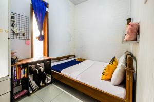 a small bedroom with a bed and a book shelf at OYO Homes 91067 Desa Wisata Santanamekar in Rajapolah