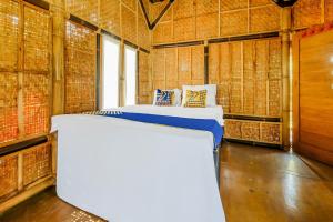 a bed in a room with bamboo walls at OYO Homes 91067 Desa Wisata Santanamekar in Rajapolah
