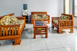 four wooden couches and a table in a room at OYO Homes 91067 Desa Wisata Santanamekar in Rajapolah