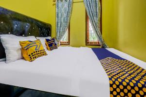 a bedroom with a white bed with pillows and a window at OYO Homes 91067 Desa Wisata Santanamekar in Rajapolah