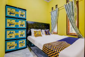 two beds in a room with yellow walls at OYO Homes 91067 Desa Wisata Santanamekar in Rajapolah
