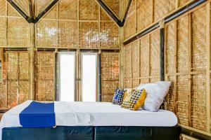 a bed in a room with some pillows on it at OYO Homes 91067 Desa Wisata Santanamekar in Rajapolah