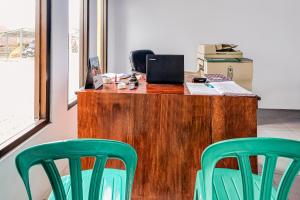 two green chairs in front of a desk with a laptop at OYO Homes 91067 Desa Wisata Santanamekar in Rajapolah