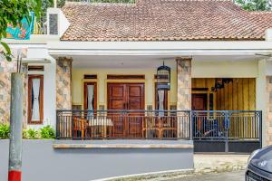 a house with a balcony with chairs on it at OYO Homes 91067 Desa Wisata Santanamekar in Rajapolah