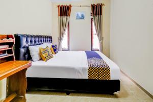 a bedroom with a large white bed and a window at OYO Homes 91067 Desa Wisata Santanamekar in Rajapolah