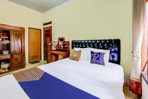 a bedroom with a large bed with blue and white sheets at OYO Homes 91067 Desa Wisata Santanamekar in Rajapolah
