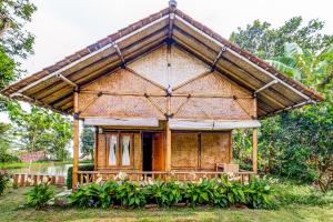 a small house with a thatched roof at OYO Homes 91067 Desa Wisata Santanamekar in Rajapolah