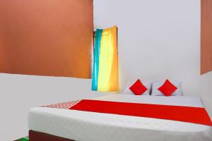 a bedroom with a bed with red pillows at OYO 91051 Penginapan Pondok Ratu 354 in Pontianak