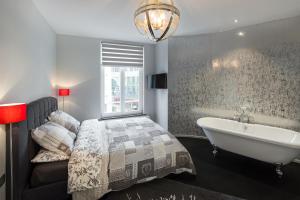 a bedroom with a bed and a tub and a window at All In One in Brussels