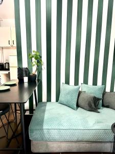 een kamer met een bank en een tafel met een gestreepte muur bij Cozy Givat Ada Countryside Stay in Giv‘at ‘Ada