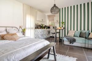 een slaapkamer met een bed, een tafel en een bank bij Cozy Givat Ada Countryside Stay in Giv‘at ‘Ada
