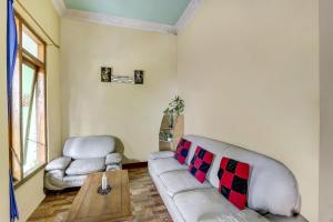 un soggiorno con un divano e un tavolo di OYO Homes 91151 Desa Wisata Kreatif Perdamaian Srumbung Gunung a Karangjati