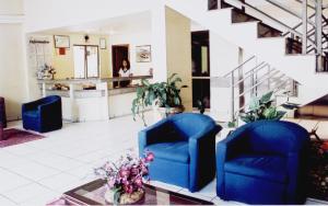 a lobby with two blue chairs and a counter at Oft Plaza Oeste Hotel in Goiânia