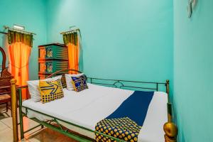 a bed with colorful pillows on it in a room at Hotel O Desa Wisata Bangunharja in Banjar